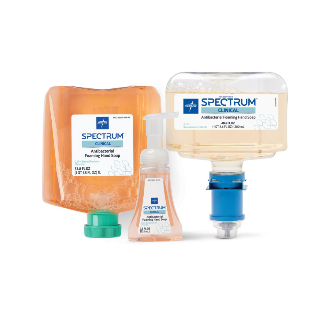 Three containers of Medline Spectrum Antibacterial Foaming Hand Soap: a refill pouch, pump bottle, and large upside-down dispenser with blue attachment. Each is transparent with orange-tinted soap for effective germ protection.